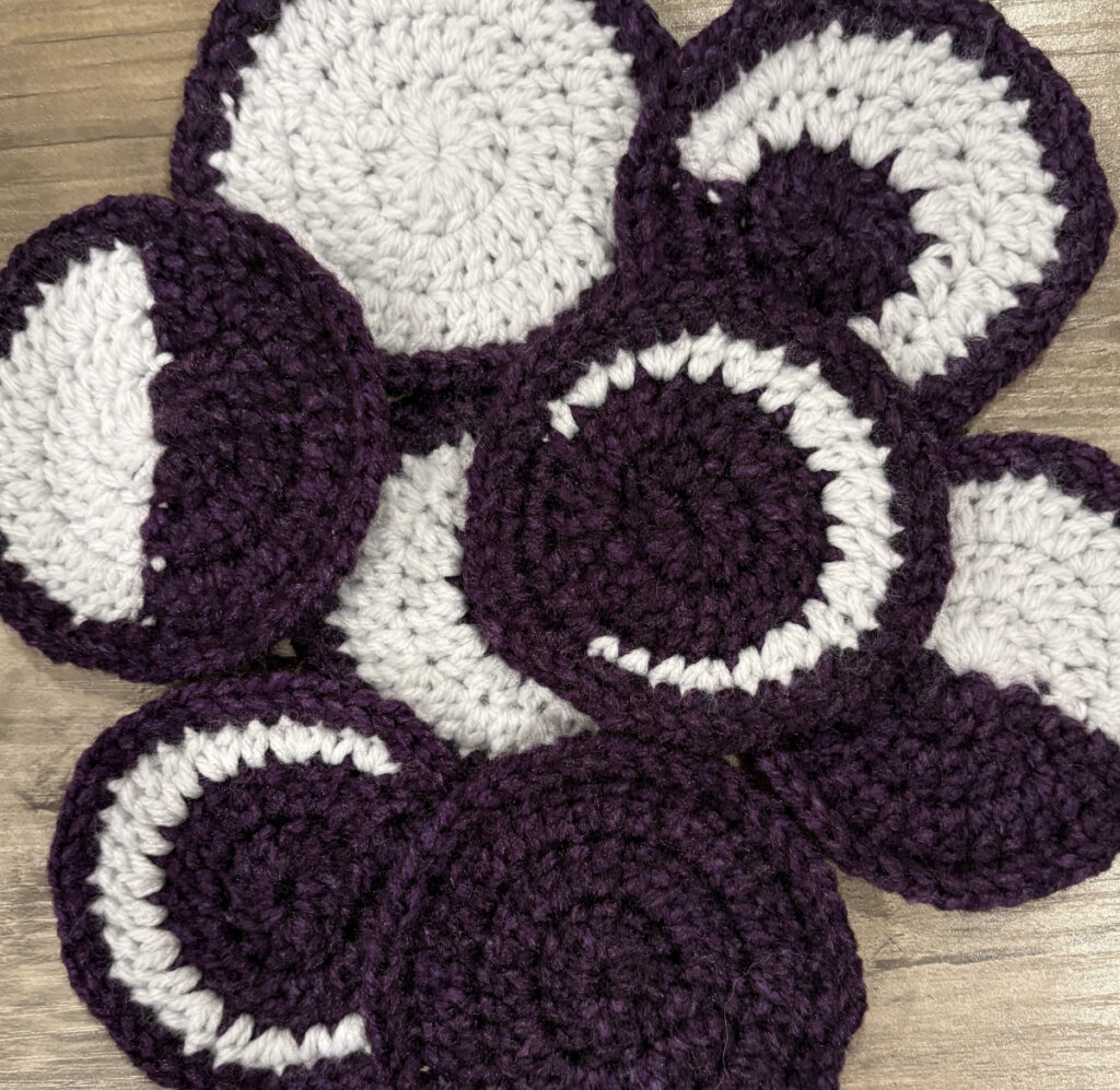 Closeup of the moon phases in purple and light grey in a pile.